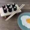 sushi van vilt op een plankje ernaast een gebakken ei van vilt