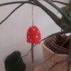 rood met witte stippen paddenstoelhanger met takje in plant