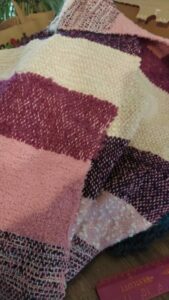handgeweven sjaal van restanten garen in pars en roze kleuren