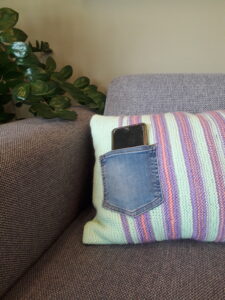 lila en zachtgroen gestreept kussen met jeans zakken voor je mobiel of afstandsbediening detailfoto