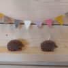 egel kaarsjes op een houten wand met mini vilten vlaggen lijntje