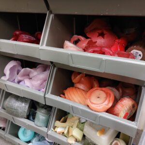 bakken met allerlei kleuren restanten van kaarsen om nieuwe kaarsen van te maken