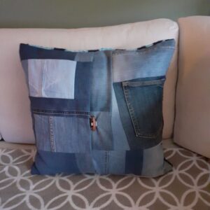 achterkant van kussen op bank van spijkerbroek patchwork en knoopsluiting