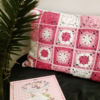 roze met wit gehaakt kussen met granny squares op bank met plant en boek
